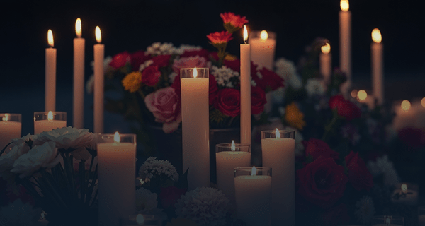 memorial candles and flowers in somber lighting, respectful professional photography