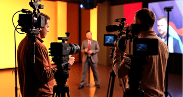 television news interview setup with cameras and lighting